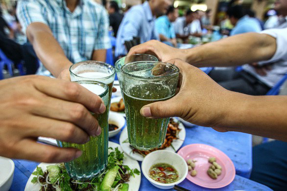 Nam giới chúc tụng nhau tại một quán bia hơi ở Hà Nội - Ảnh: TTO