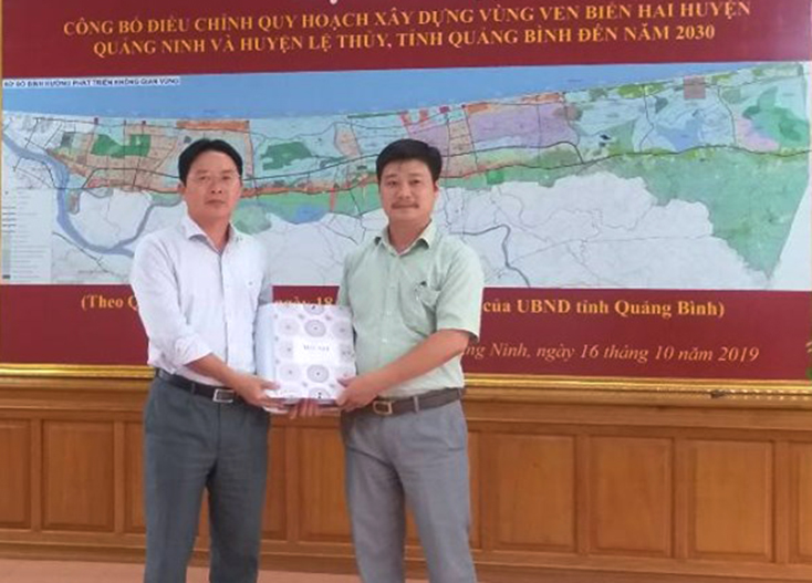 Đại diện lãnh đạo Sở Xây dựng bàn giao hồ sơ điều chỉnh quy hoạch cho lãnh đạo UBND huyện Quảng Ninh.
