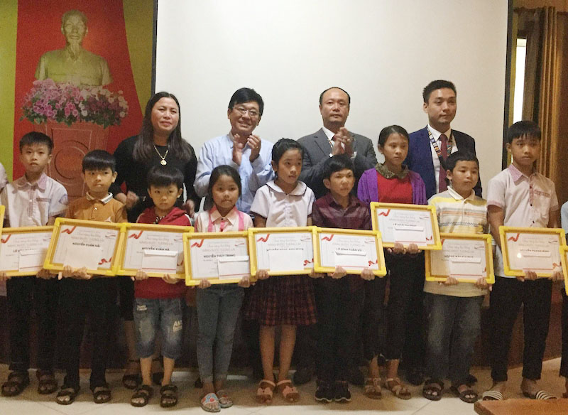Đại diện Công ty BHNT Prudential và Hội Chữ thập đỏ tỉnh trao học bổng cho các em học sinh
