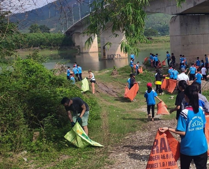 Du khách nước ngoài cùng học sinh tham gia nhặt rác tại khu vực cầu Xuân Sơn, xã Sơn Trạch.