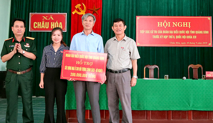 Các đại biểu Quốc hội trao tiền hỗ trợ xây dựng nhà cho các gia đình chính sách và hộ nghèo tại huyện Tuyên Hóa.