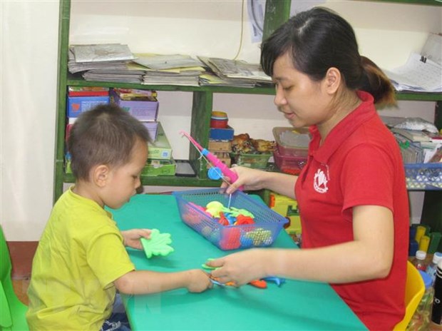 Giáo viên can thiệp, trị liệu và hỗ trợ hòa nhập cho trẻ tự kỷ ở Ninh Bình. (Ảnh: Thùy Dung/TTXVN)
