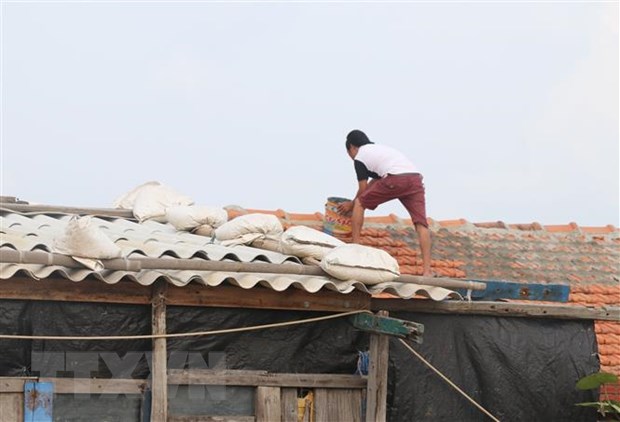 Người dân phường Phú Đông, thành phố Tuy Hòa, Phú Yên gia cố lại mái nhà để ứng phó với bão số 6. (Ảnh: Phạm Cường/TTXVN)
