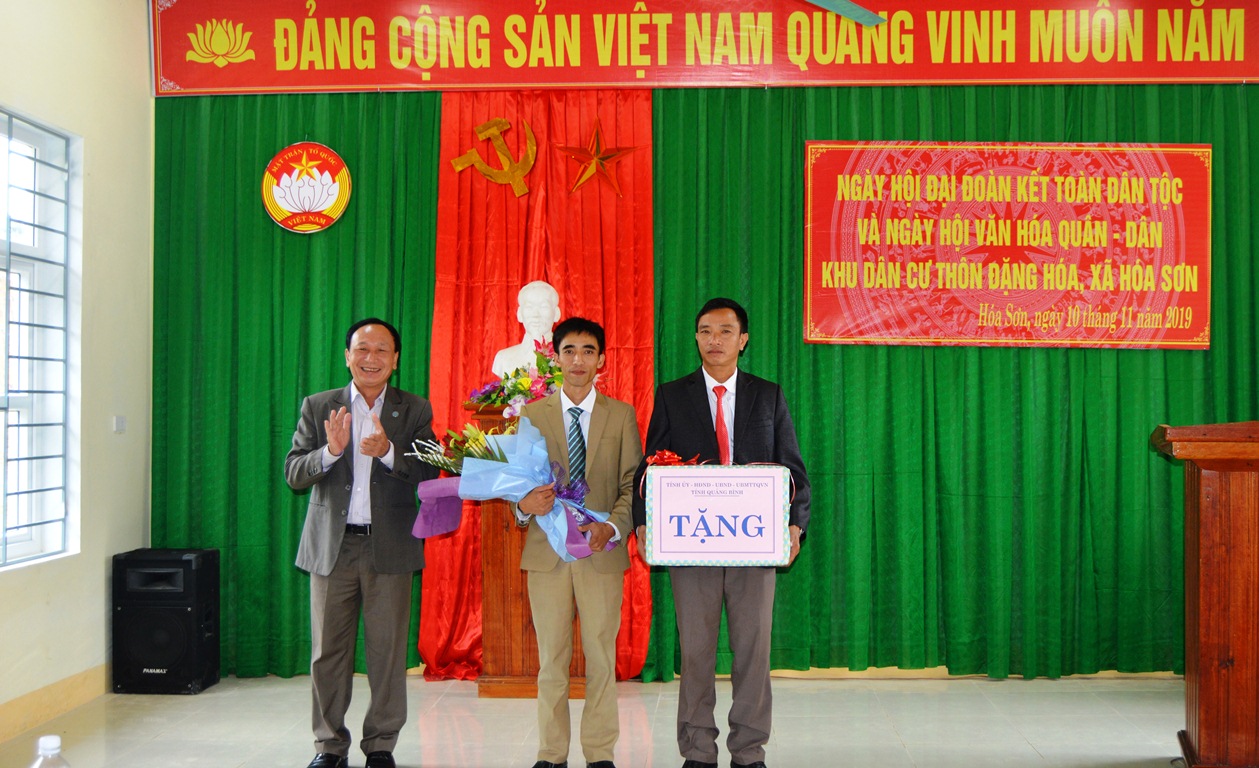 Đồng chí Trưởng ban Nội chính Tỉnh ủy Trần Hải Châu tặng hoa và quà chúc mừng nhân dân và cán bộ thôn Đặng Hóa (xã Hóa Sơn, huyện Minh Hóa).
