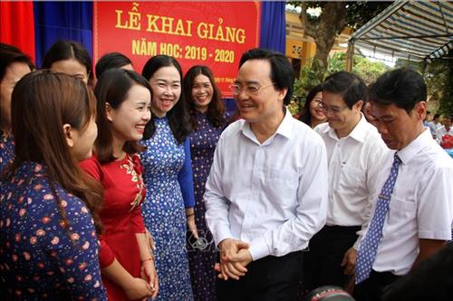 Bộ trưởng Phùng Xuân Nhạ với thầy cô Trường tiểu học Tân Hoá, huyện Minh Hóa (Quảng Bình). Ảnh: Văn Tý/TTXVN.