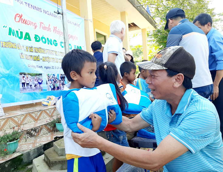 Anh Phan Thanh Sơn, Trưởng đoàn thiện nguyện của Hội Tennis ngành IT TP. Đà Nẵng trao quà cho học sinh tiểu học bản Cà Xen.