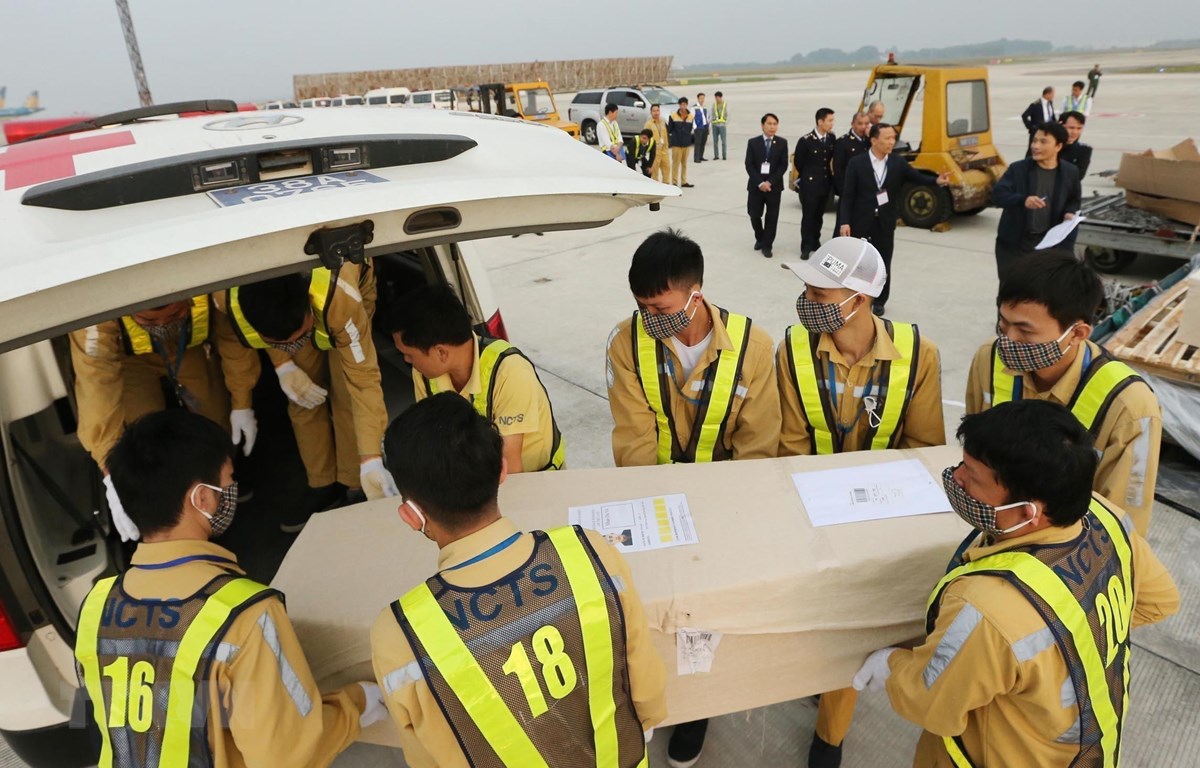 Nhân viên sân bay quốc tế Nội Bài vận chuyển thi thể các nạn nhân lên ô tô để đưa về quê nhà. (Ảnh: Lâm Khánh/TTXVN)