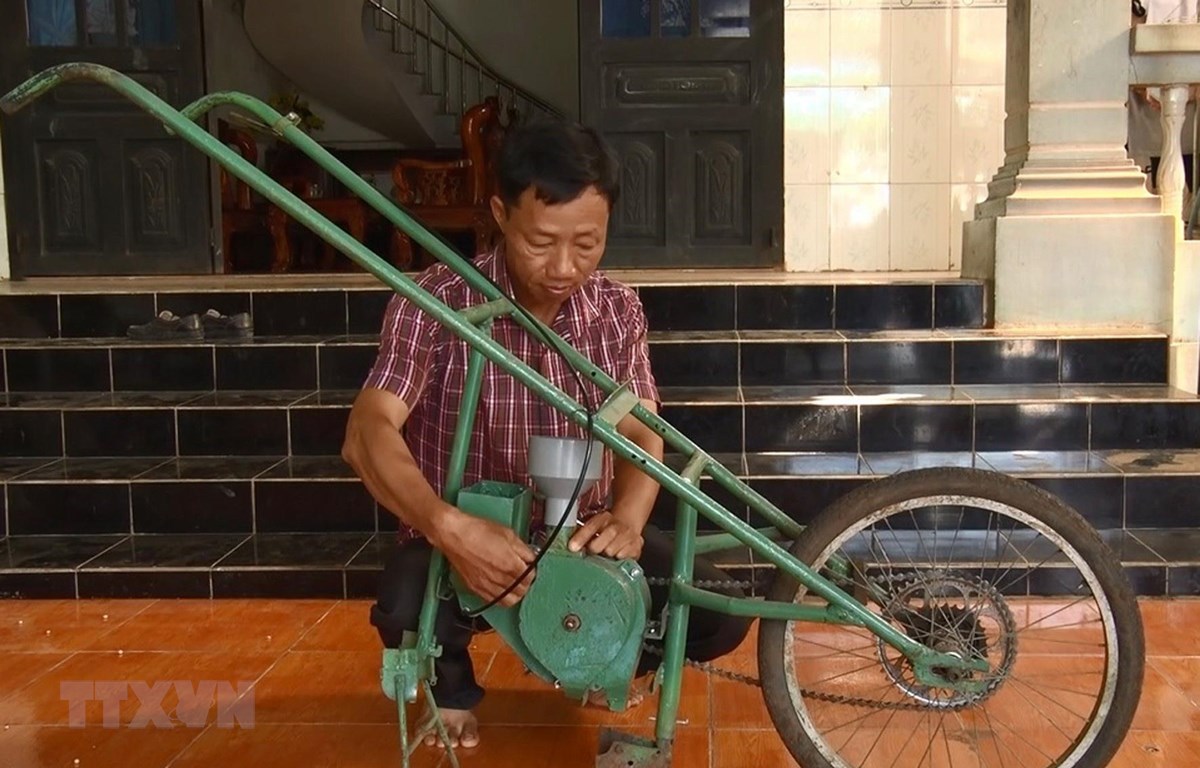 Anh Nguyễn Văn Anh với chế chiếc máy gieo hạt và bón phân. (Ảnh: Lê Xuân/TTXVN)