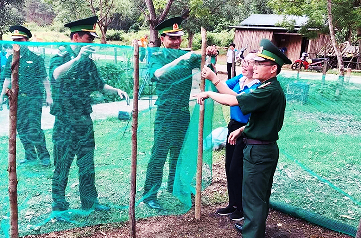 Cán bộ, chiến sỹ Đồn Biên phòng Cà Xèng tham gia làm chuồng nuôi gà cho bà con xã Thượng Hóa, huyện Minh Hóa.