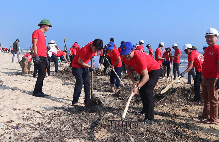 Lực lượng đoàn viên, thanh niên làm vệ sinh môi trường tại bãi biển Nhật Lệ.    