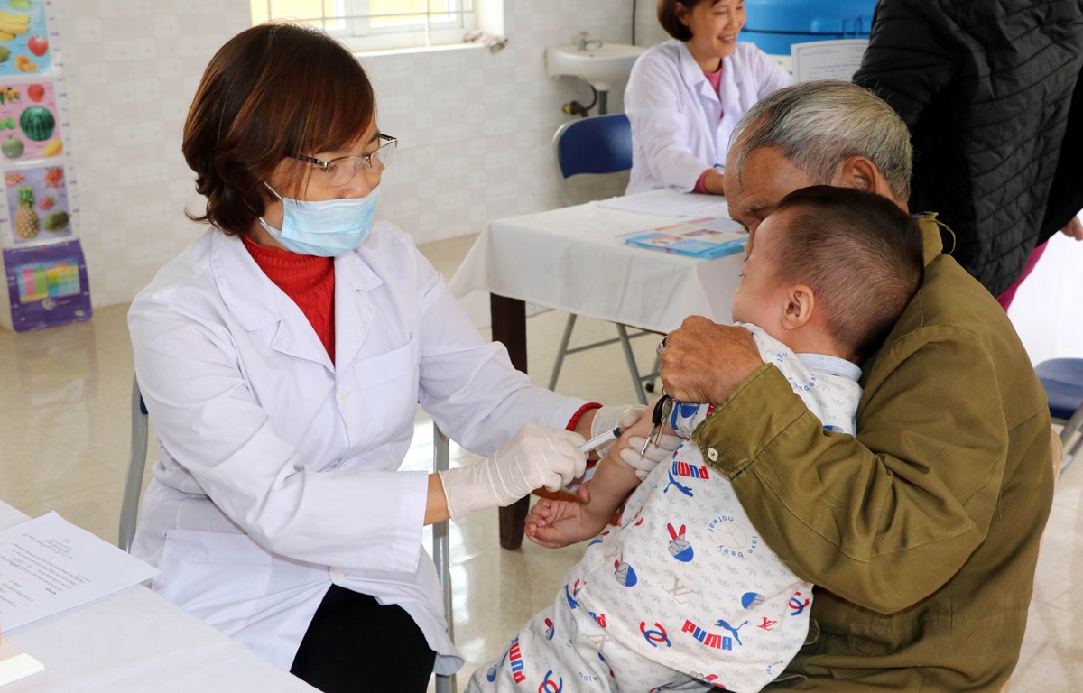 Cán bộ y tế tiêm phòng cho trẻ. (Ảnh: Nguyễn Lành/TTXVN)