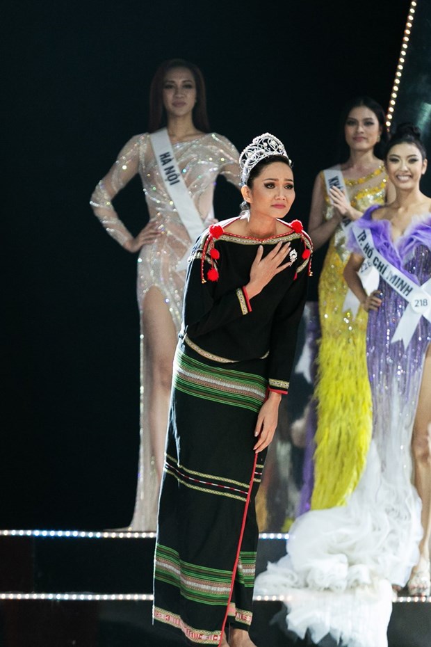 Hoa hậu H’Hen Niê xuất hiện với đôi chân trần và trang phục Êđê, đội vương miện trong màn Final Walk trước khi trao lại danh hiệu cho người kế vị tiếp theo. (Ảnh: Sang Đào/Vietnam+)