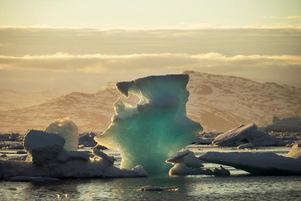 Ánh nắng phản chiếu tuyệt đẹp trên một tảng băng trôi gần Tasiilaq, Greenland. Ảnh do Lucas Jackson chụp ngày 16-6-2018. Hàng tỉ tấn nước tan ra từ các khối băng khổng lồ ở Greenland và Nam Cực đang đổ về các đại dương có thể dẫn tới nhiều hình thái thời tiết cực đoan hơn, gây xáo trộn khí hậu Trái Đất trong nhiều thập kỷ tới. Lời cảnh báo trên được nêu ra trong một nghiên cứu đăng tải trên tạp chí Nature số ra ngày 6-2. Theo nhà nghiên cứu tại Trung tâm Nghiên cứu Nam Cực của Đại học Victoria (New Zealand), không chỉ gây cản trở dòng chảy đại dương, nước băng tan còn làm thay đổi nhiệt độ trên thế giới. Ngoài ra, việc khối lượng lớn tảng băng bị mất đi tại Nam Cực còn kìm hãm nước biển ấm ở dưới bề mặt biển, làm xói mòn sông băng và điều này khiến mực nước biển dâng - Ảnh: REUTERS