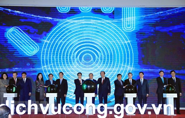 Thủ tướng Nguyễn Xuân Phúc và các đại biểu thực hiện nghi thức khai trương Cổng Dịch vụ công Quốc gia. (Ảnh: Thống Nhất/TTXVN)