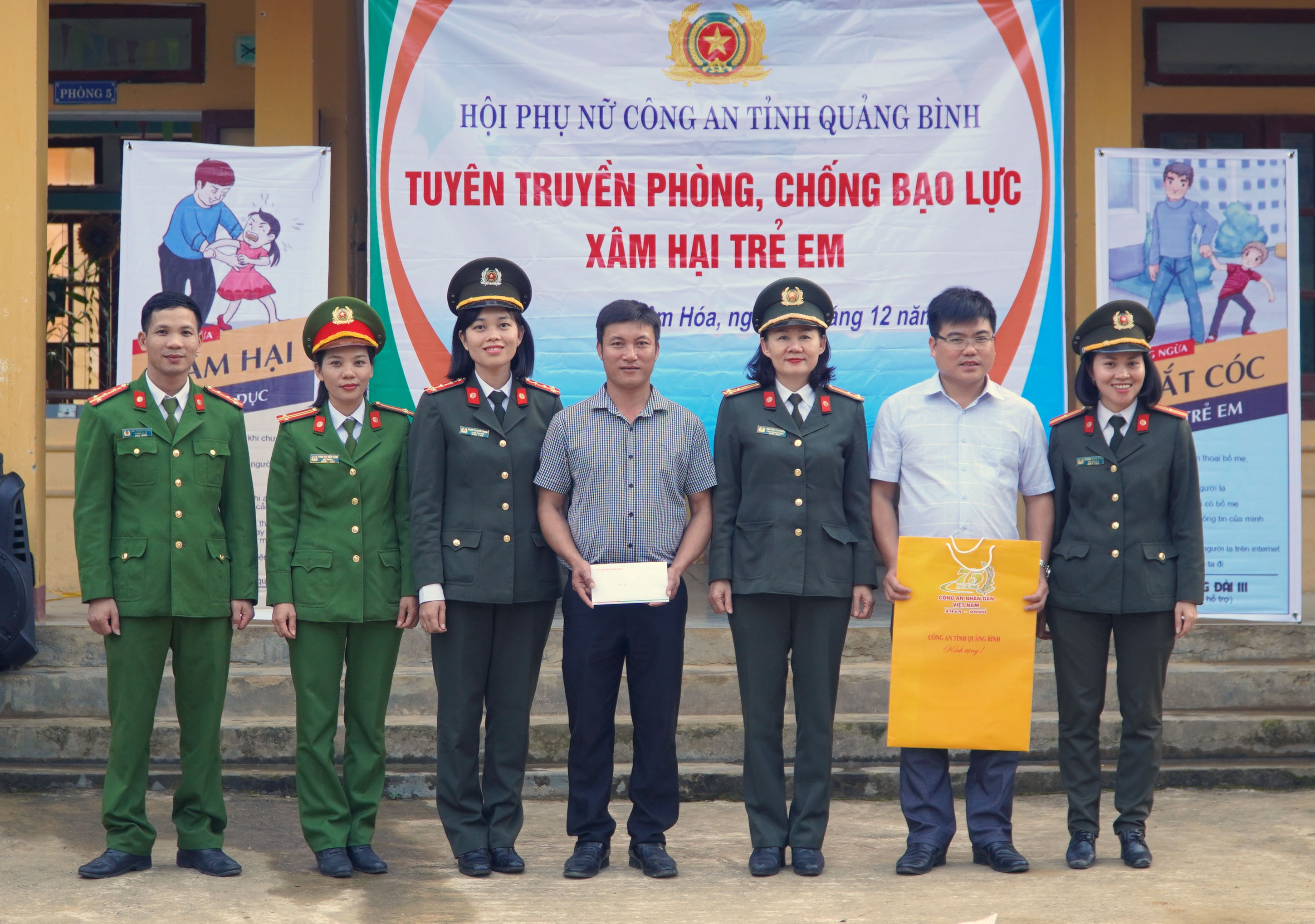 Đại diện Ban Nữ công Công an tỉnh tặng quà và chụp ảnh lưu niệm cùng cán bộ, giáo viên Trường Trường phổ thông dân tộc bán trú tiểu học và THCS Lâm Hóa