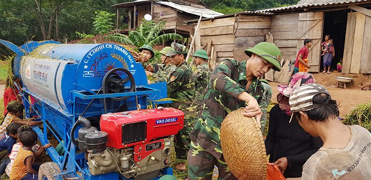 Cán bộ, chiến sỹ Đồn Biên phòng CKQT Cha Lo giúp người dân bản Ka Ai thu hoạch lúa.