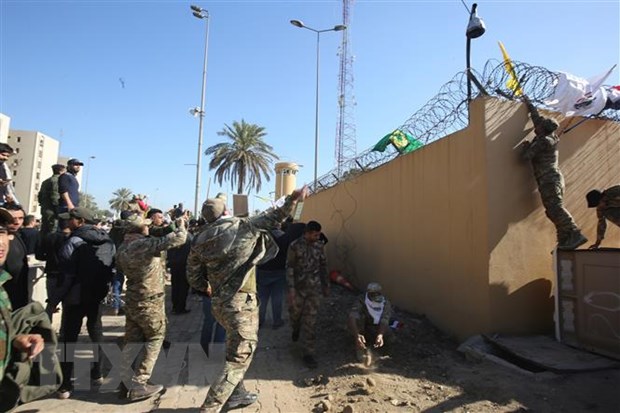  Các tay súng thuộc nhóm phiến quân Hashd al-Shaabi biểu tình bên ngoài sứ quán Mỹ ở Baghdad, Iraq. (Ảnh: AFP/TTXVN)