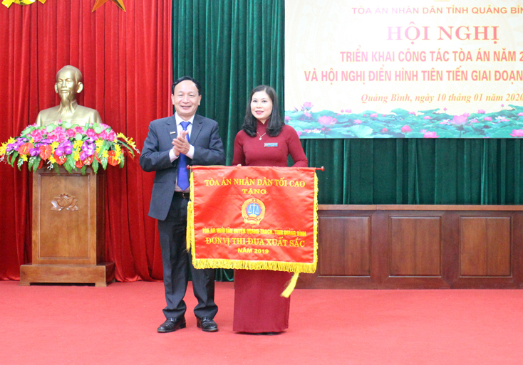 Đồng chí Trần Hải Châu, Ủy viên Thường vụ, Trưởng ban Nội chính Tỉnh ủy trao cờ thi đua TAND cho TAND huyện Quảng Trạch