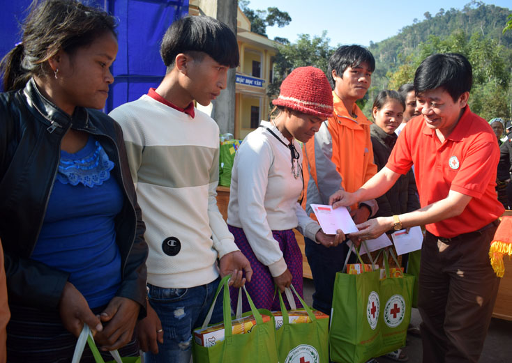 Đại diện Hội Chữ thập đỏ tỉnh trao quà hỗ trợ cho người nghèo ở xã Thượng Trạch.