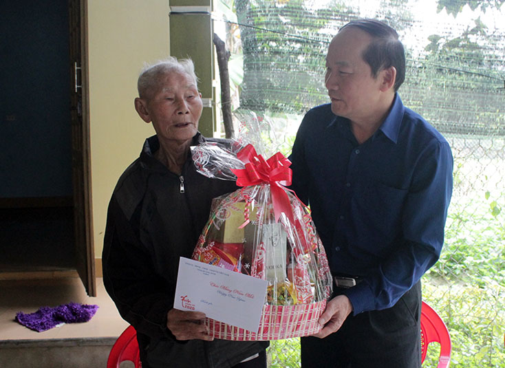 Đồng chí Trần Xuân Vinh, Trưởng ban Tổ chức Tỉnh ủy thăm, tặng quà đồng chí Phạm Văn Điểu, xã Quảng Trường, Quảng Trạch