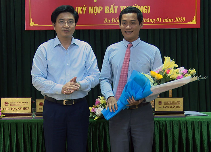 Đồng chí Trương An Ninh, Bí thư Thị ủy Ba Đồn tặng hoa chúc mừng đồng chí Nguyễn Văn Tình nhận nhiệm vụ.