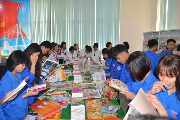 Các em học sinh và đoàn thanh niên đọc sách, báo tại không gian trưng bày.