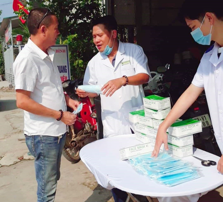 Một quầy thuốc ở xã Tiến Hóa phát khẩu trang y tế cho người dân. 