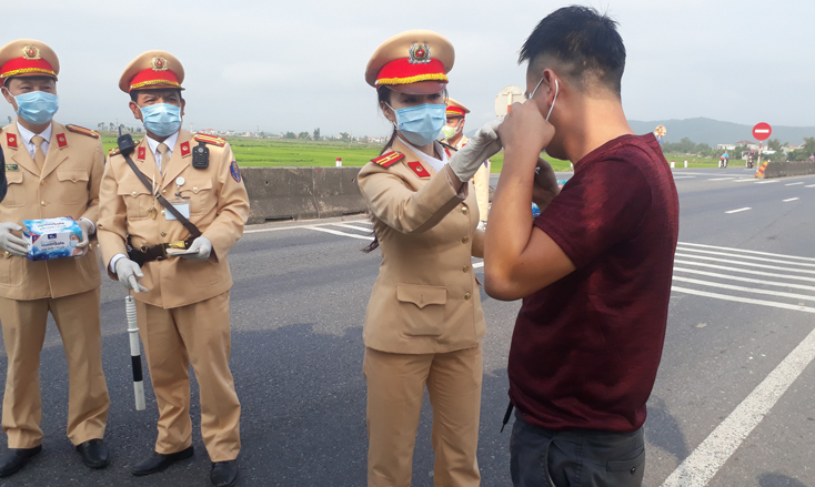 Cán bộ, chiến sỹ Phòng CSGT Công an tỉnh phát miễn phí khẩu trang y tế và hướng dẫn người điều khiển phương tiện sử dụng đúng cách.