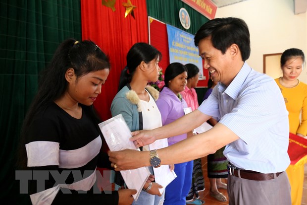 Đại diện cơ quan chức năng tỉnh Quảng Trị trao Quyết định nhập Quốc tịch Việt Nam cho người dân ở vùng biên giới Việt Nam-Lào. (Ảnh: Nguyên Lý/TTXVN)