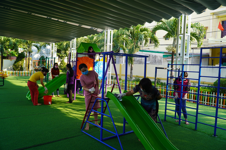 Đoàn viên công đoàn Trường tiểu học Đồng Phú (TP. Đồng Hới) tích cực vệ sinh, khử khuẩn khu vui chơi vận động của học sinh.