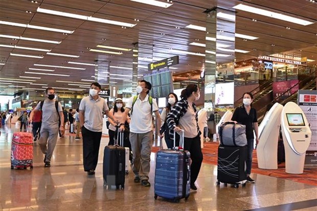 Khách du lịch đeo khẩu trang để phòng tránh lây nhiễm virus corona tại sân bay quốc tế Changi, Singapore. (Ảnh: AFP/TTXVN)