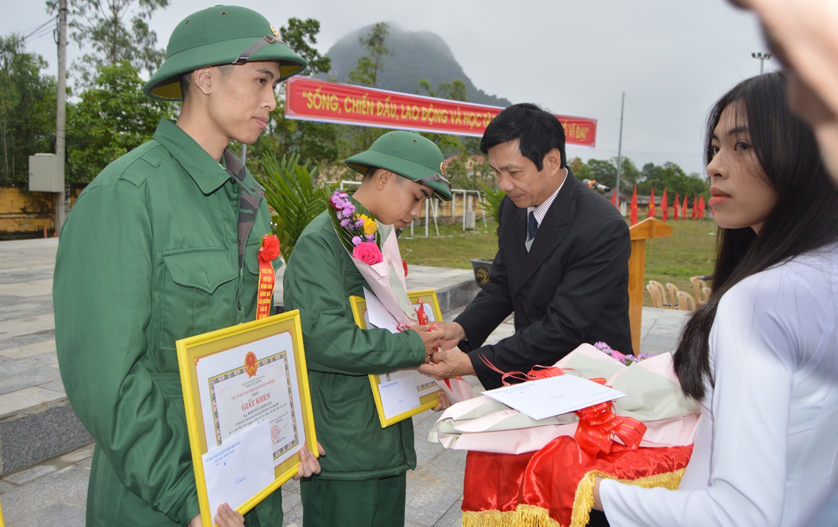 Đồng chí Trưởng ban Dân vận Tỉnh ủy Nguyễn Công Huấn tặng hoa, động viên tân binh huyện Minh Hóa lên đường nhập ngũ.