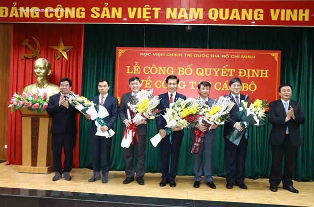 Giáo sư-tiến sỹ Nguyễn Xuân Thắng, Giám đốc Học viện Chính trị quốc gia Hồ Chí Minh tặng hoa, chúc mừng các cán bộ lãnh đạo mới được bổ nhiệm. (Ảnh: Văn Điệp/TTXVN)