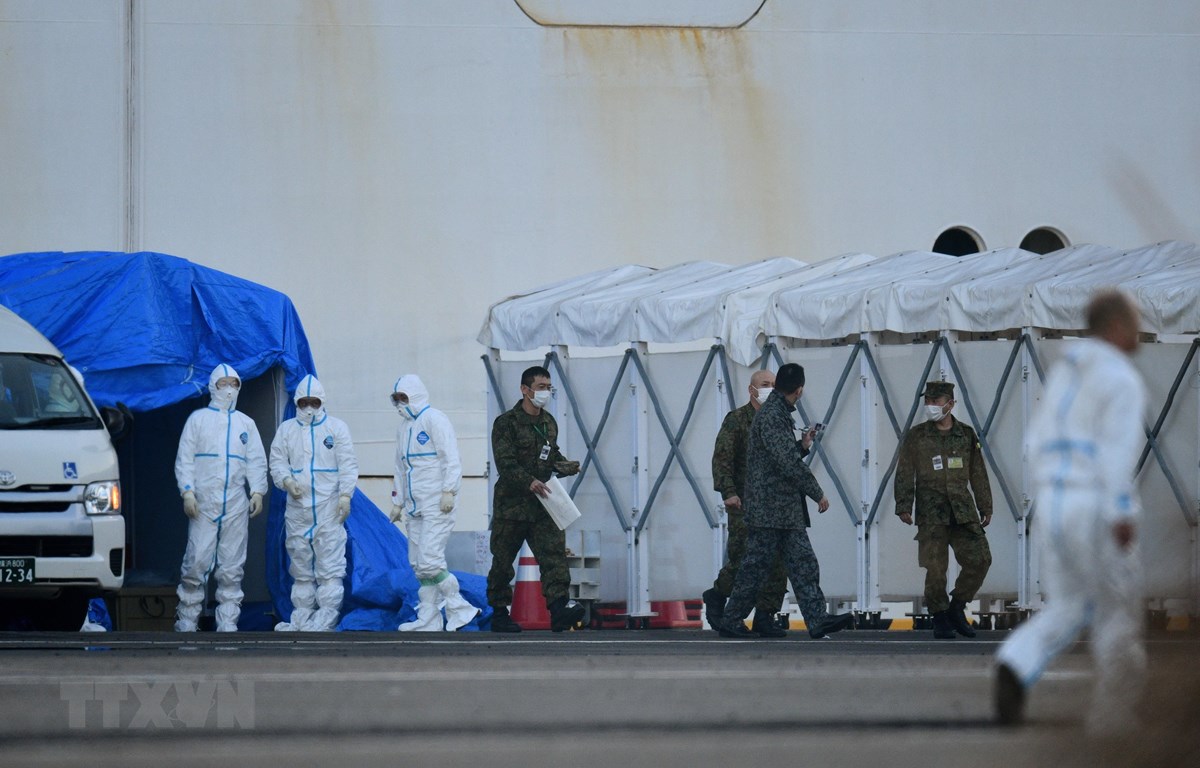 Nhân viên y tế làm nhiệm vụ gần du thuyền Diamond Princess bị cách ly tại cảng Yokohama, Nhật Bản ngày 13-2. (Ảnh: AFP/TTXVN)
