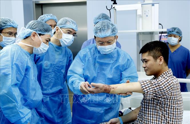  Trung tướng, GS,TS, Thầy thuốc nhân dân Mai Hồng Bàng, Giám đốc bệnh viện Trung ương Quân đội 108 kiểm tra chức năng vận động của bệnh nhân sau ca ghép. Ảnh: TTXVN phát.