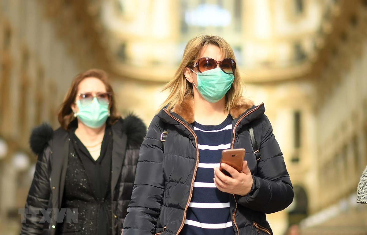 Người dân đeo khẩu trang để phòng tránh lây nhiễm COVID-19 tại Milan, Italy. (Ảnh: THX/TTXVN)