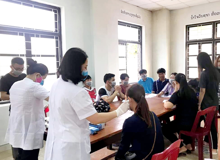 Kiểm tra sức khỏe và kê khai lịch trình đi lại của sinh viên Lào vào chiều 2-3-2020.