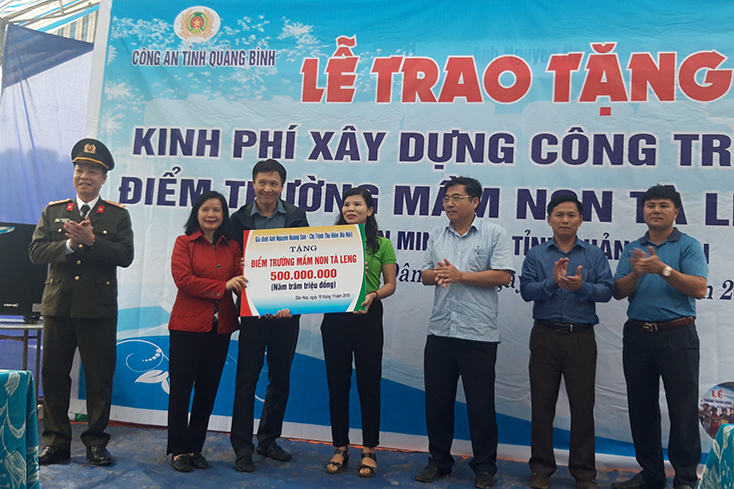 Đại tá Trần Hải Quân, Giám đốc Công an Quảng Bình và gia đình anh Nguyễn Hoàng Sơn, chị Trịnh Thu Hiền trao tặng kinh phí xây dựng trường mầm non bản Tà Leeng.