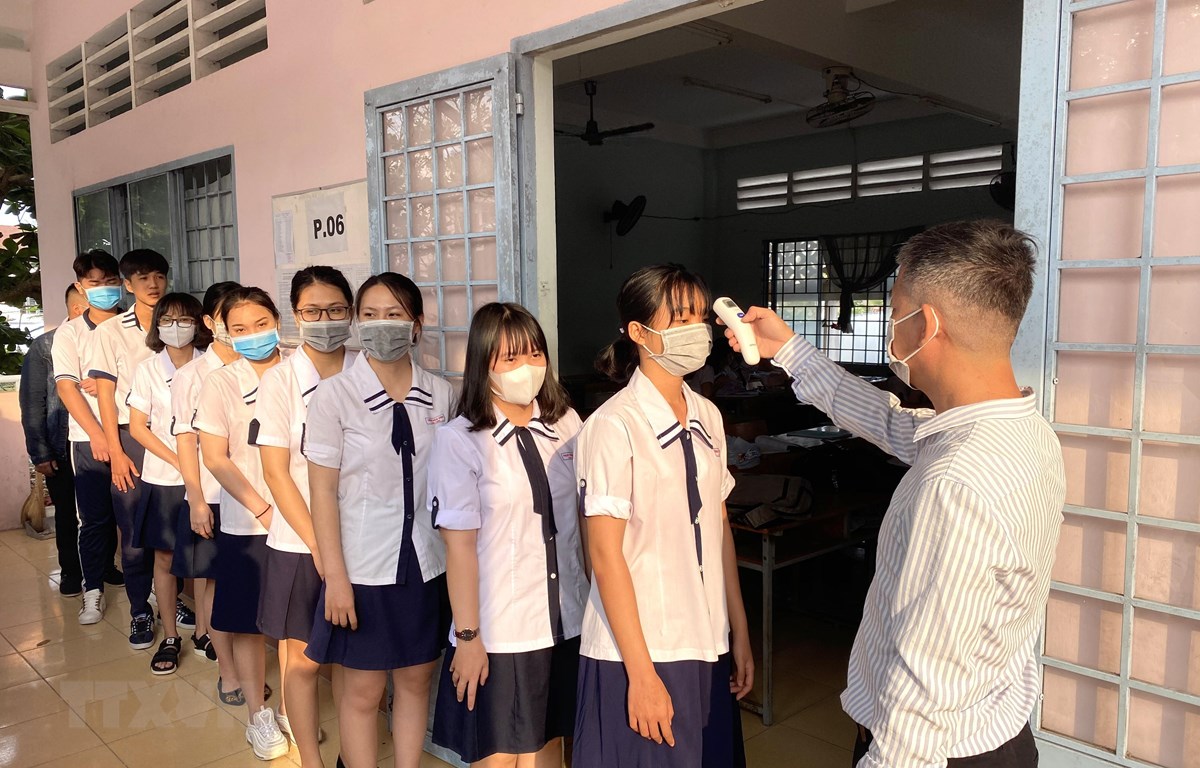 Trường THPT Vĩnh Long (thành phố Vĩnh Long, Việt Nam) đo thân nhiệt cho học sinh ngày 2-3. (Ảnh: Lê Thúy Hằng/TTXVN)