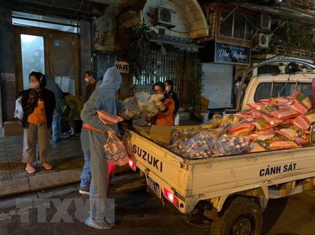 Lực lượng chức năng quận Ba Đình vận chuyển hàng hóa, nhu yếu phẩm trong đêm phục vụ người dân khu vực cách ly phố Trúc Bạch. (Ảnh: Minh Nghĩa/TTXVN)