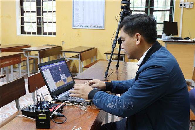 Giáo viên trường Trung học cơ sở Nguyễn Đăng Đạo, thành phố Bắc Ninh kiểm tra chất lượng video trước khi đăng tải lên mạng internet cho học sinh. Ảnh: Thanh Thương/TTXVN