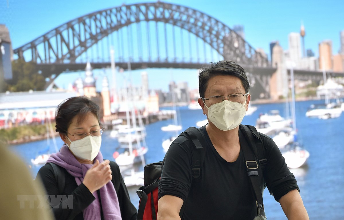 Hành khách đeo khẩu trang phòng lây nhiễm COVID-19 tại sân bay ở Sydney, Australia. (Ảnh: AFP/TTXVN)