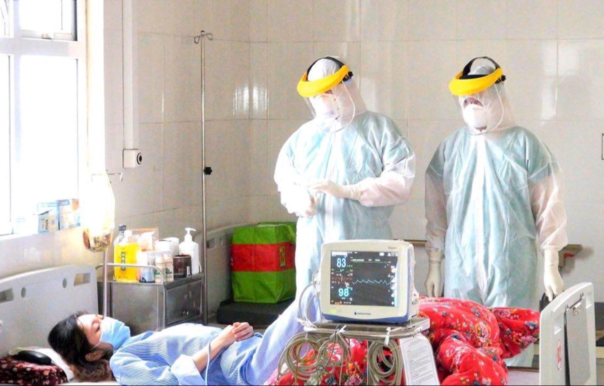  Các y bác sĩ chăm sóc tận tình cho một ca nhiễm COVID-19 (Ảnh: PV/Vietnam+)