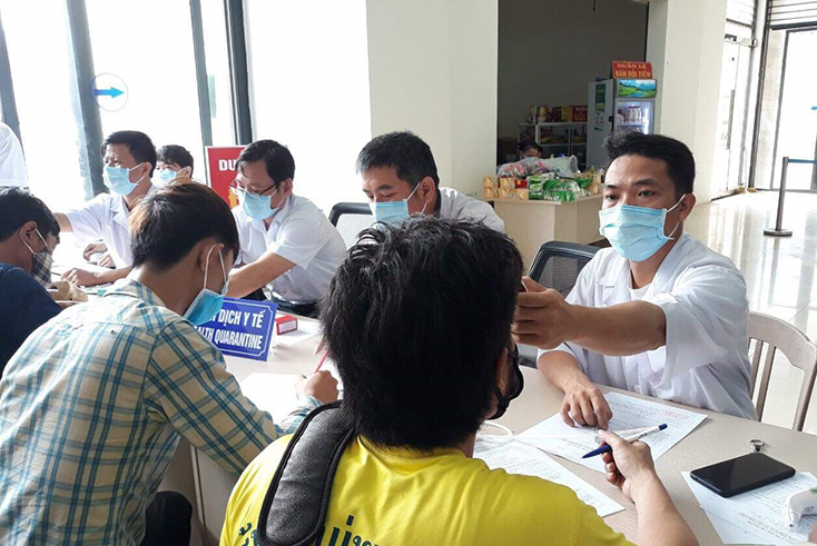 Cán bộ y tế thực hiện kiểm tra thân nhiệt đối với khách nhập cảnh vào Quảng Bình