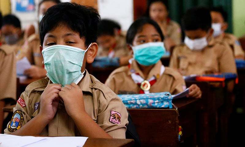Học sinh Indonesia đeo khẩu trang tới trường. Ảnh: Reuters