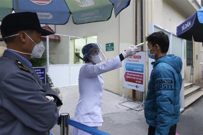 Người vào bệnh viện Xanh Pôn (Hà Nội) được kiểm tra thân nhiệt và khai báo lịch trình di chuyển. Ảnh: Minh Quyết/ TTXVN