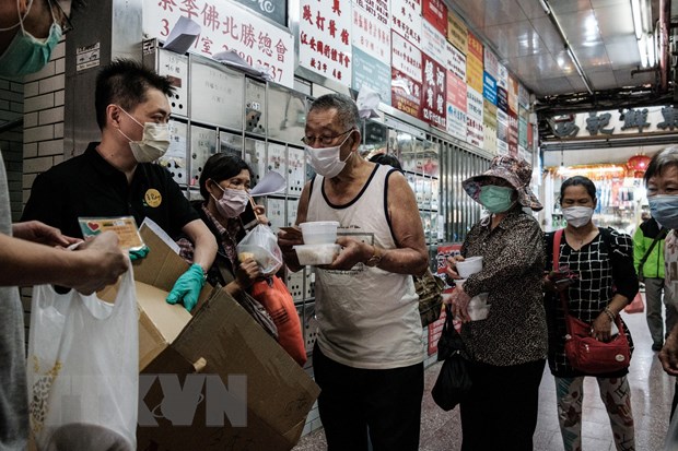  Trong ảnh: Người dân đeo khẩu trang phòng lây nhiễm COVID-19 tại Hong Kong, Trung Quốc. (Ảnh: AFP/TTXVN)