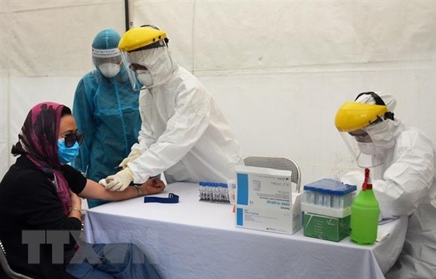 Lấy mẫu xét nghiệm virus SARS-CoV-2 cho người dân tại trạm xét nghiệm nhanh quận Ba Đình. (Ảnh: TTXVN phát)