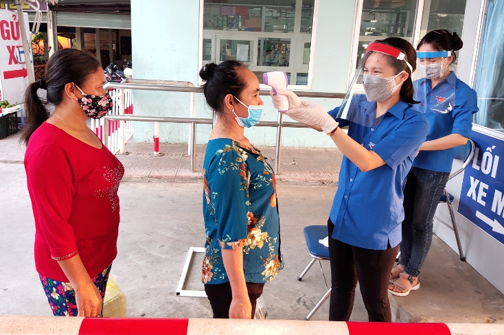    Lực lượng ĐVTN tiến hành kiểm tra thân nhiệt cho người dân tại cổng Bệnh viện hữu nghị Việt Nam-Cuba Đồng Hới.