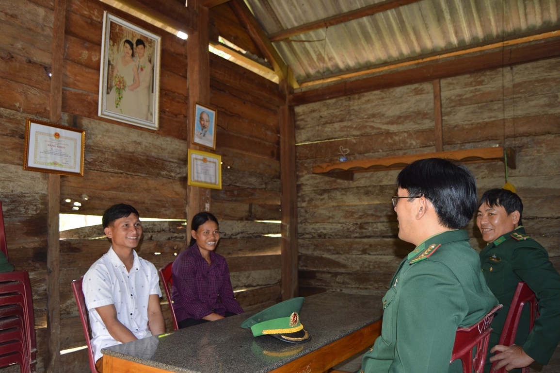  Bí thư Chi bộ, Trưởng bản Mò O Ồ Ồ Cao Xuân Long (bìa trái) đang bàn công việc với cán bộ Đồn Biên phòng Cà Xèng.